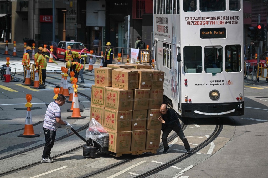 Two men push a pallet of goods over tram tracks in Hong Kong on Wednesday. Donald Trump’s tariffs could create an opening for the city, if China implements certain tactics that pay off. Photo: AFP