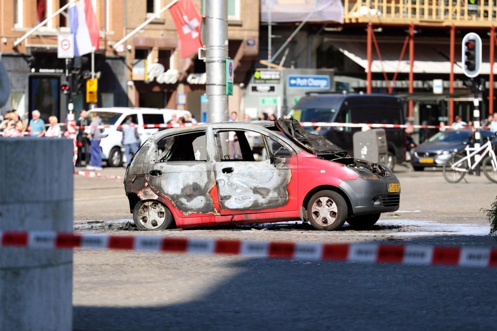 Police tape surrounds the burned-out car out on Dam Square near the National Monument in Amsterdam on Thursday. Photo: EPA-EFE