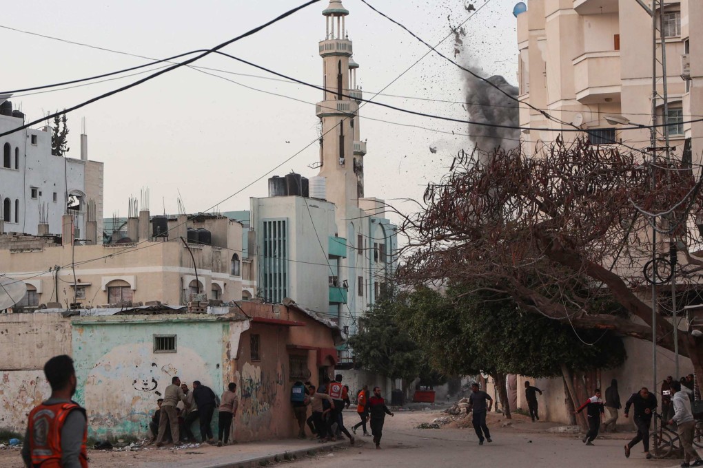 People and Palestinian rescuers run for cover as Israeli strike hits a school in the Tuffah neighbourhood in Gaza City. Photo: AFP