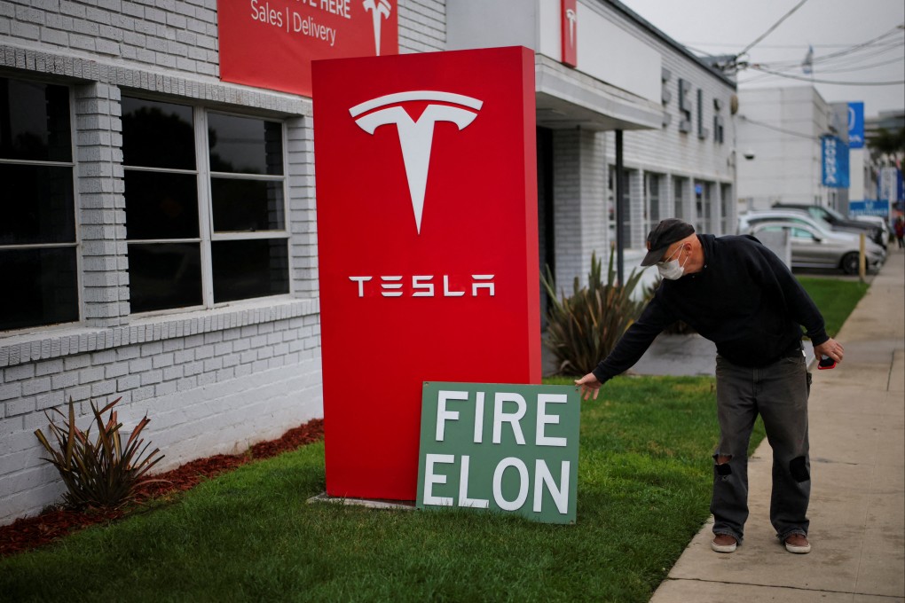 A man places a sign outside a Tesla dealership during a protest against Tesla and its CEO Elon Musk outside a Tesla dealership in Los Angeles, California, on March 14. Photo: Reuters