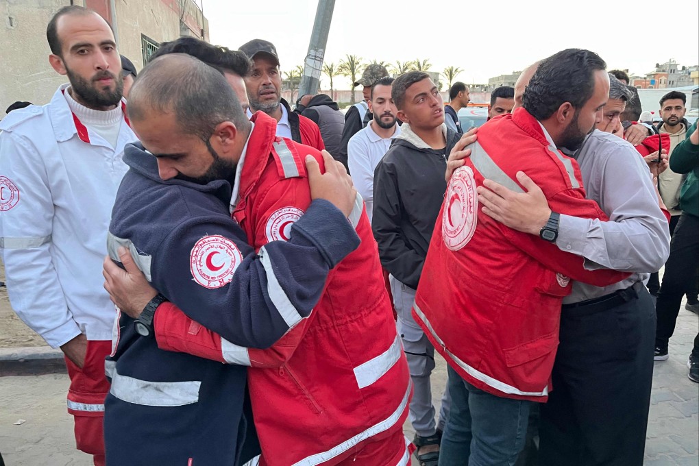 First responders embrace each other at Nasser Medical Complex in Khan Yunis in the southern Gaza Strip on Sunday as the bodies of Palestinian first responders who were killed a week before in Israeli military fire on ambulances arrive at the facility. Photo: AFP