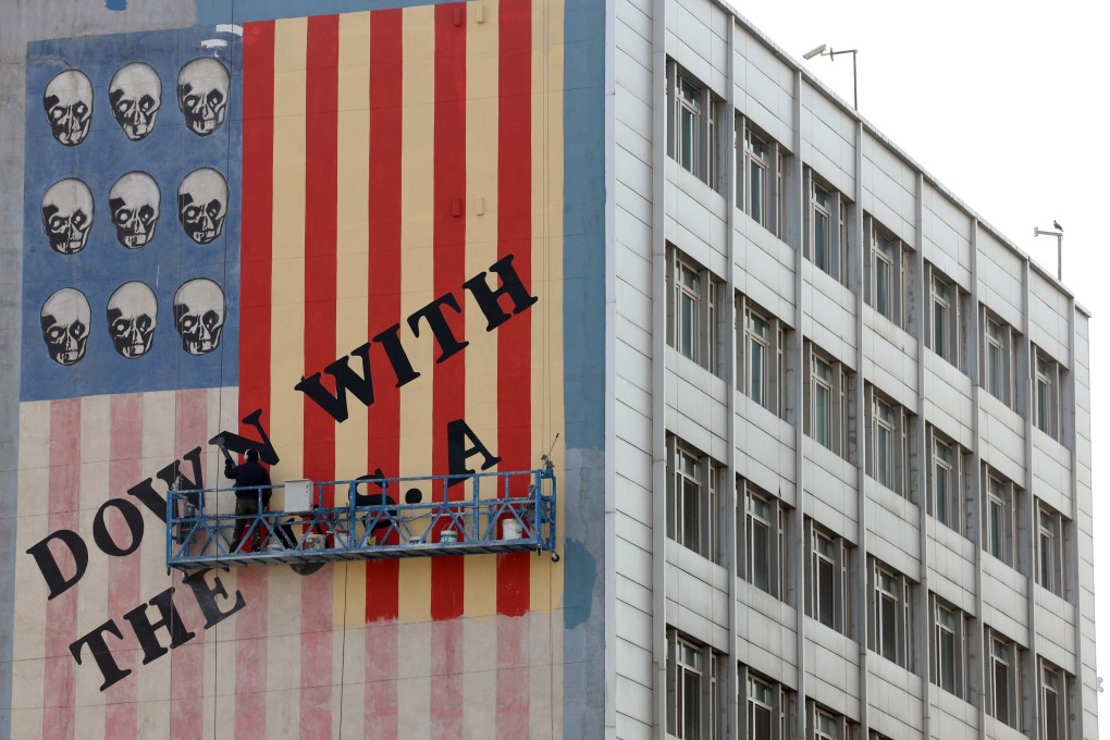 A man repaints one of the famous anti-US murals in Tehran, Iran, on March 29. Photo: EPA-EFE