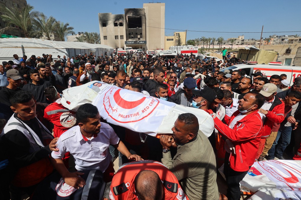 Members of the Palestine Red Crescent and other emergency services carry bodies of fellow rescuers killed a week earlier by Israeli forces, during a funeral procession at Nasser hospital in Khan Younis in the southern Gaza Strip on Monday. Photo: TNS