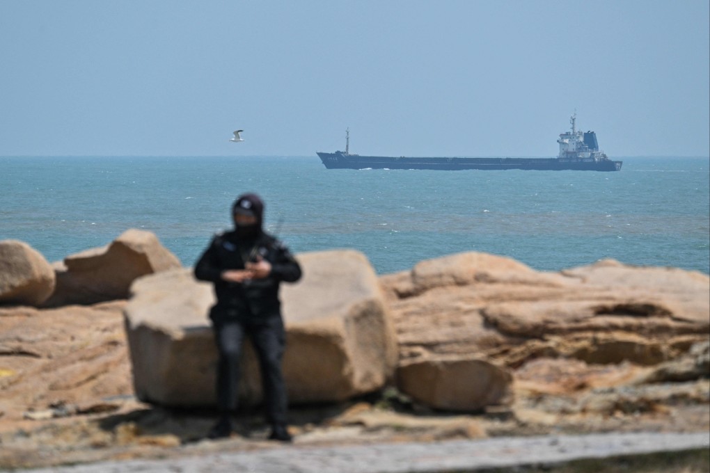 A guard stands by as a cargo ships sails next to Pingtan island, the closest point between mainland China and Taiwan’s main island, in Fujian province on Wednesday. Photo: AFP