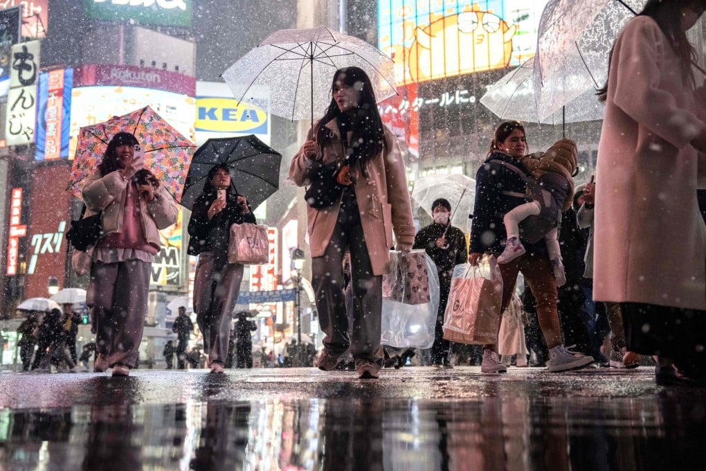 People walk along Shibuya Crossing during snowfall in Tokyo on March 4. Japan’s safe-haven credentials, the boom in overseas tourism amid the plunge in the yen and growing confidence in reflation help explain why Tokyo was the best-performing commercial property investment market among the leading cities in Asia for the last three years. Photo: AFP