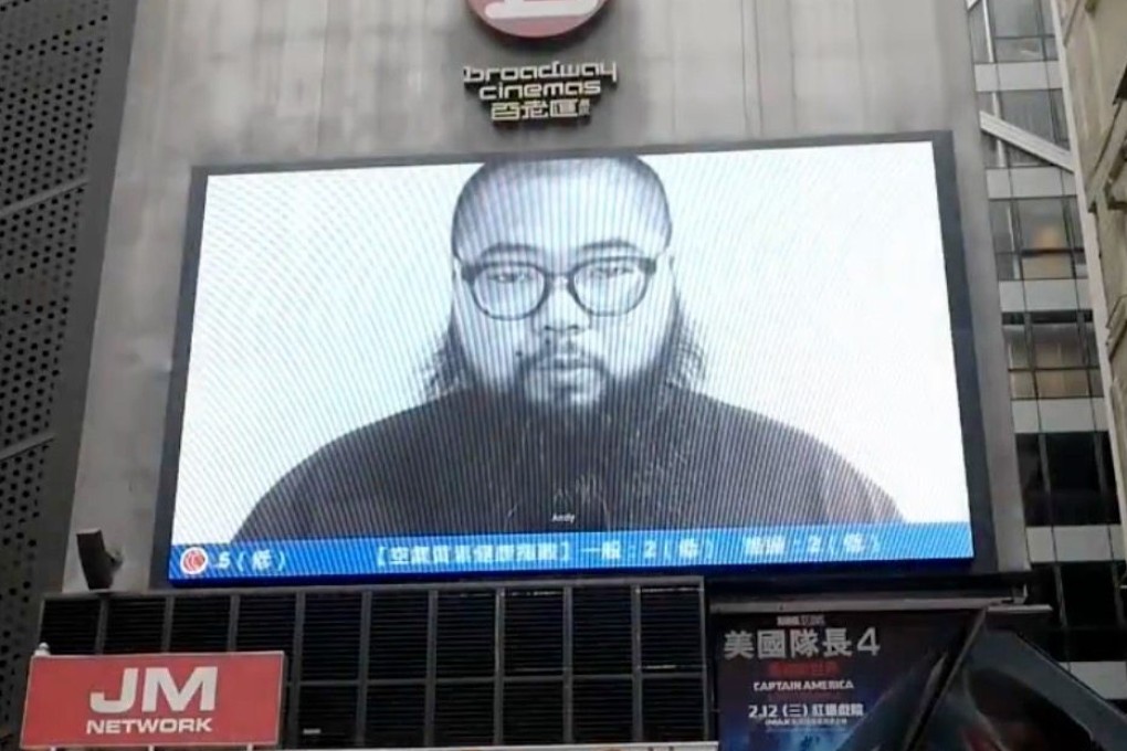 The face of dissident Chinese-Australian artist Badiucao is shown on an electronic billboard in Sai Yeung Choi Street South, Mong Kok, Hong Kong. The image is from a 4-second clip the artist submitted to an Italian gallery under a false name for inclusion in a video art reel. Photo: X/badiucao