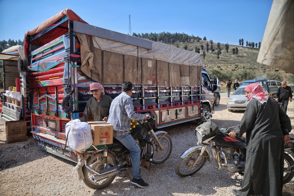 People receive food aid provided by the World Food Programme (WFP) at the Bab al-Rahma camp near the town of Kafr Lusin, north of Idlib, Syria, on March 12. Photo: EPA-EFE