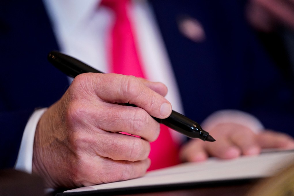 US President Donald Trump signs an executive order at the White House in Washington on Tuesday using a pen that might have been made in China. Photo: Reuters