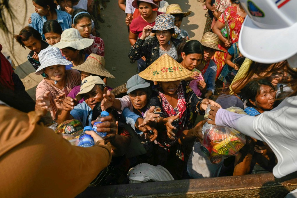 People reach up for food aid being distributed in Sagaing, Myanmar, on April 3, following the March 28 earthquake. Photo: AFP