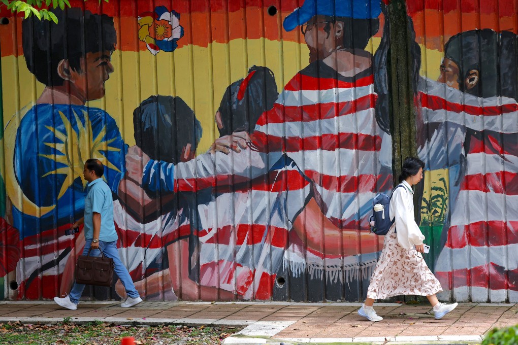 People pass by a mural of the Malaysian national flag in Kuala Lumpur on Monday. Photo: EPA-EFE