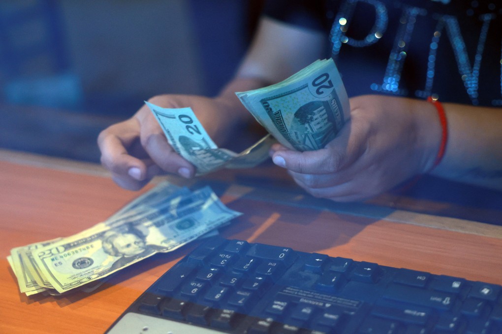 A worker at a currency exchange shop in Ciudad Juarez, Mexico, counts US dollars on April 9 after US President Donald Trump said he would temporarily lower new tariffs on many countries, but not China. Photo: Reuters