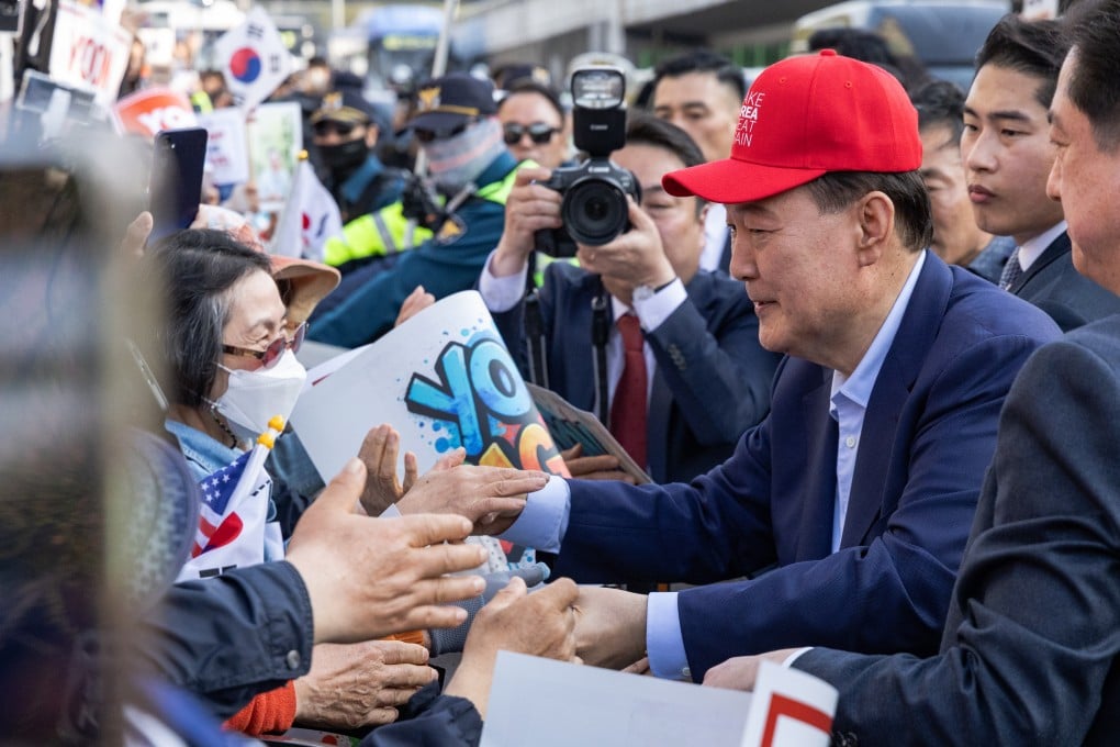 Former South Korean president Yoon Suk-yeol shakes hands with his supporters as he leaves the presidential residence on Friday, a week after the country’s top court upheld his impeachment. Photo: Kim Jung-yeop