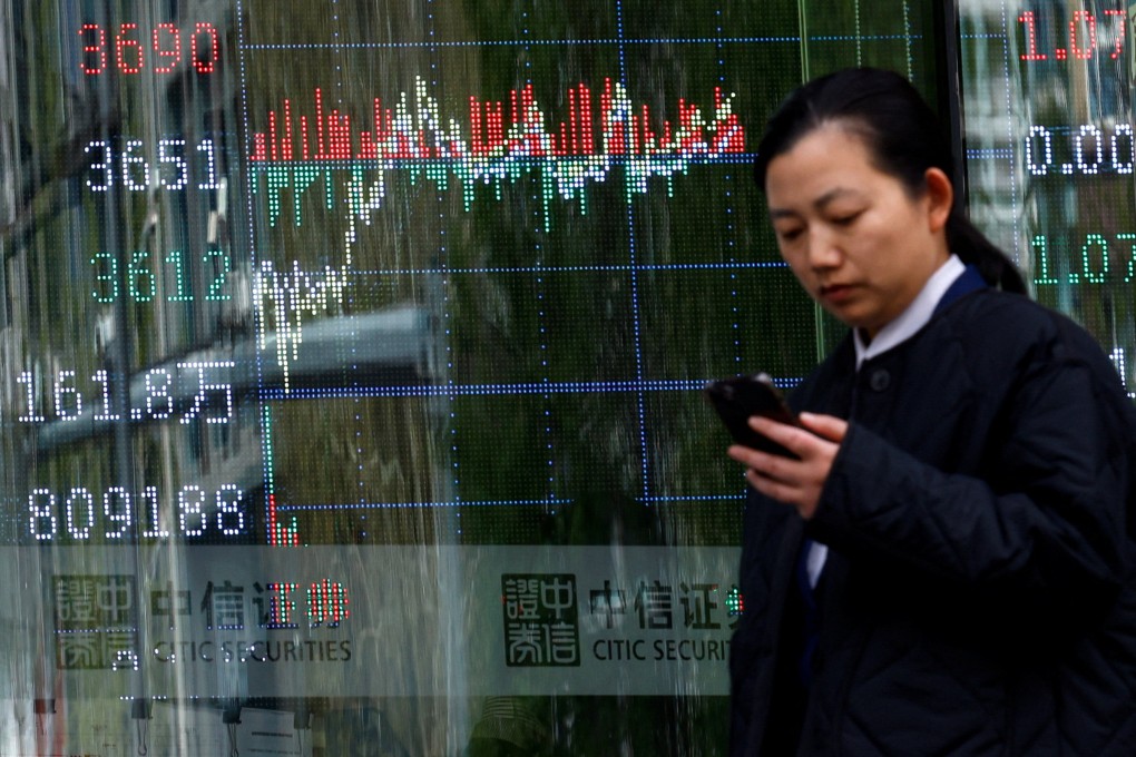 A woman walks past a Beijing brokerage house display board showing stock index information on Wednesday. Photo: Reuters