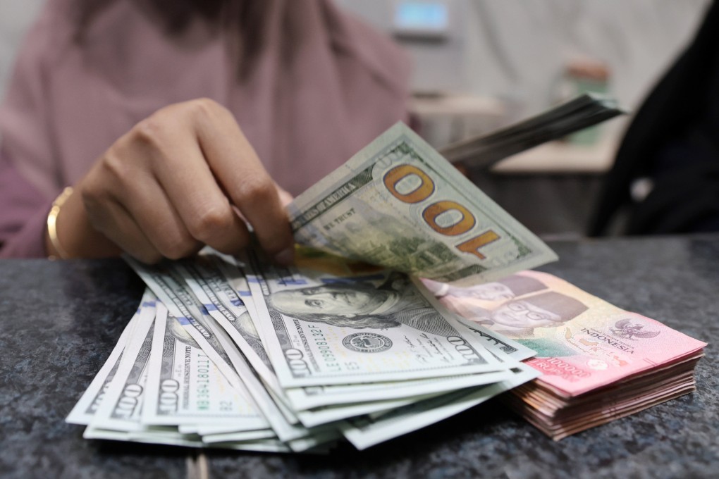 A worker counts US dollar and rupiah notes at a money changer in Jakarta, Indonesia. The rupiah on Wednesday fell to its lowest in history against the dollar before rebounding slightly on Thursday. Photo: EPA-EFE