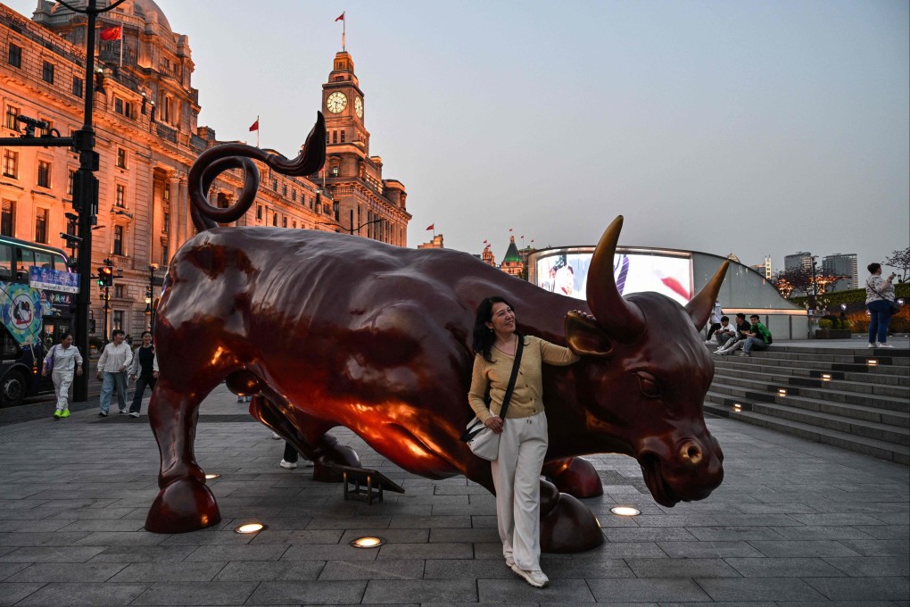 A woman poses for a picture next to The Bund Bull sculpture in Shanghai on April 9, 2025. Chinese consumers in Beijing mulled their spending habits and said they are prepared to forego American brands if that means avoiding the pinch from the escalating trade war with Washington. Photo: AFP