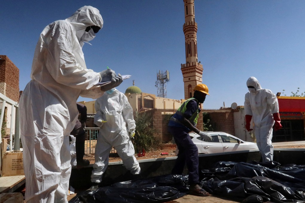 Sudanese Red Crescent volunteers work near bodies recovered from a well in the state of Khartoum, Sudan, in March. Photo: Reuters