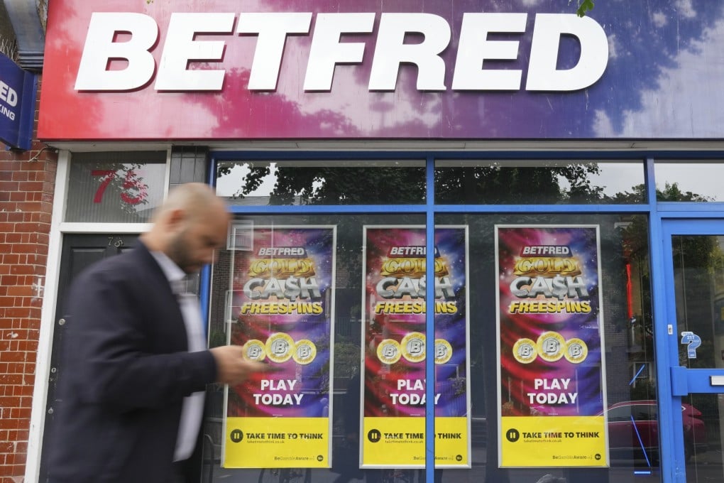 A man walks past a betting shop in London. Fifteen people allegedly used insider information regarding ex-PM Rishi Sunak’s election date for unfair gains. Photo: AP