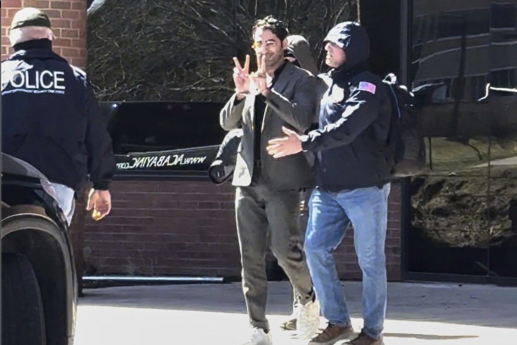 Mohsen Mahdawi, a Palestinian man who led protests against the war in Gaza as a student at Columbia University, gives a peace sign as he is detained at the US Citizenship and Immigration Services office in Colchester, Vermont on Monday. Photo: Christopher Helali via AP
