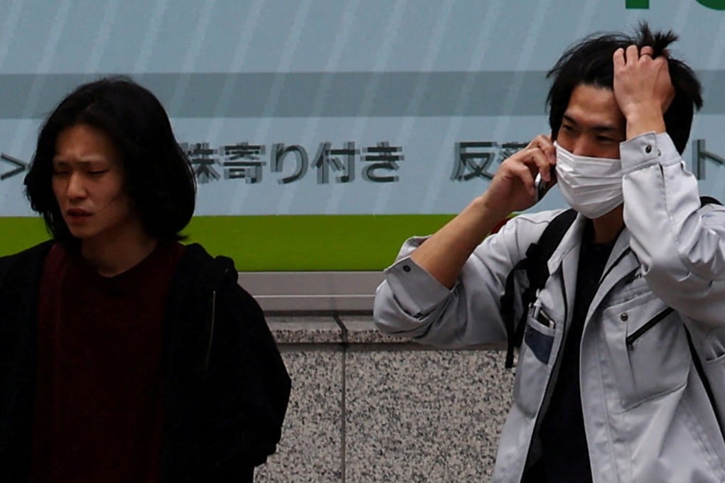 People walk past an electronic screen displaying share prices outside a brokerage in Tokyo, Japan, on Friday. Photo: Reuters