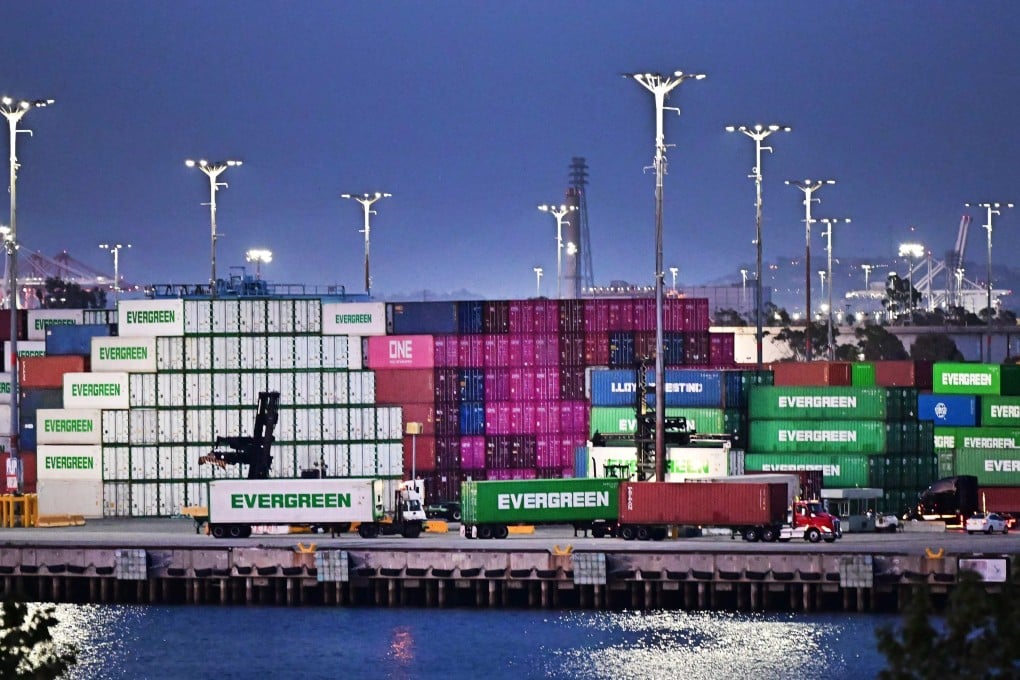 Container trucks make their way past shipping containers stacked high at the Port of Los Angeles in California on Monday. Photo: AFP