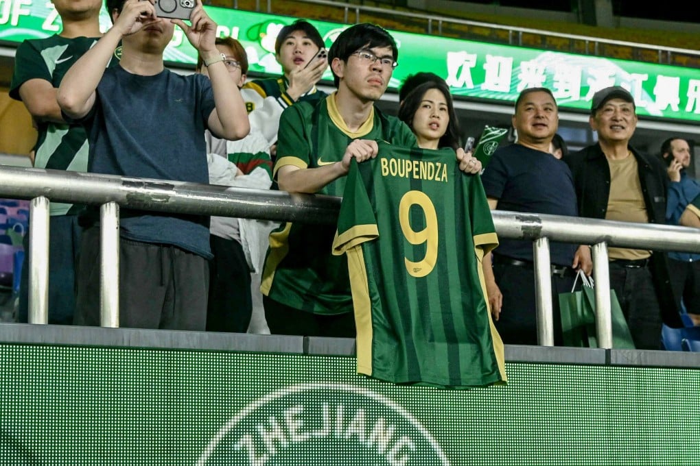 A fan holds a shirt with the name and number of Gabon striker Aaron Boupendza during the Chinese Super League match between Zhejiang FC and Meizhou Hakka in Hangzhou on Wednesday. Photo: AFP