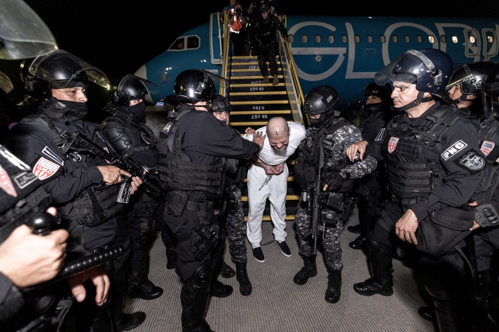 Salvadoran police officers escort an alleged member of the Venezuelan gang Tren de Aragua to be imprisoned in the Terrorism Confinement Centre in Tecoluca, El Salvador, in March. Photo: Secretaria de Prensa de la Presidencia via Reuters