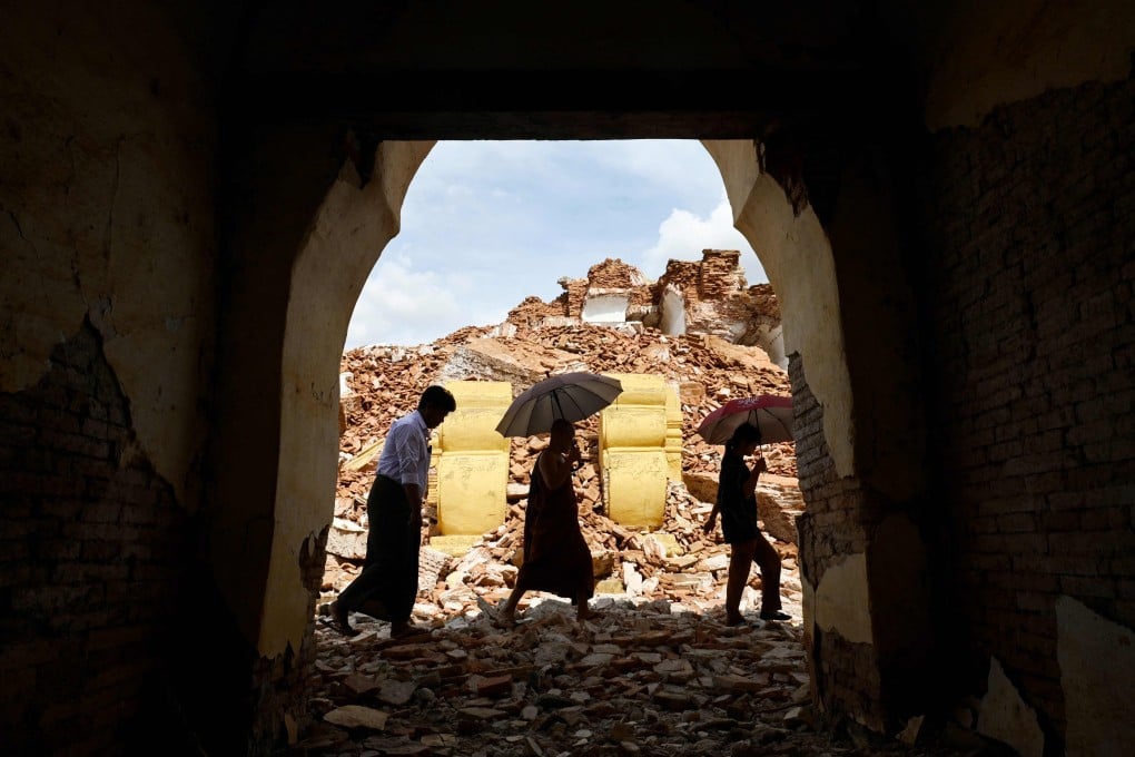 People walk past debris in the damaged 19th century Me Nu Brick monastery in Inwa on the outskirts of Mandalay on April 12, following the devastating March 28 earthquake. Photo: AFP