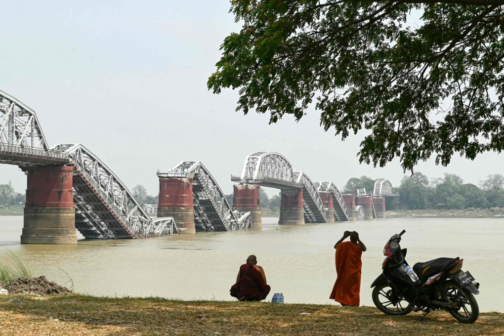 A monk takes photos on the banks of the Irrawaddy River in front of the collapsed Ava Bridge, also known as the Inwa Bridge, in Sagaing, Myanmar, on April 3. Photo: AFP