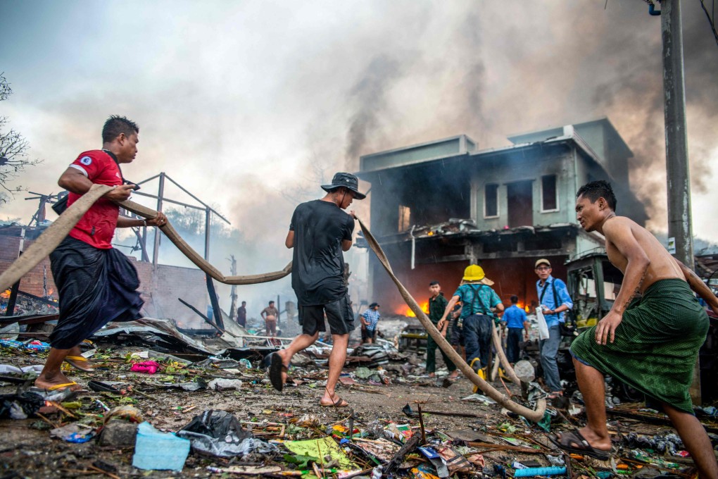 People extinguish a fire in a building that destroyed in a bombardment carried out by Myanmar’s military in Thabeikkyin Township in Mandalay Region of Myanmar on Saturday. Photo: AFP