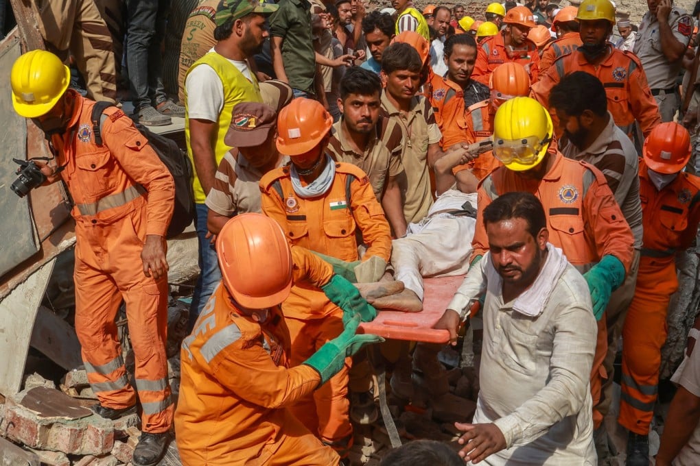 India’s National Disaster Response Force personnel carry out a person extracted from the rubble of a residential building that collapsed in New Delhi’s Mustafabad area on Saturday. Photo: EPA-EFE