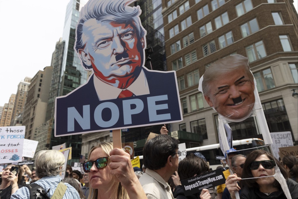Protesters hold signs with deicting Trump with a Hitler mustache in New York on Saturday. Photo: dpa