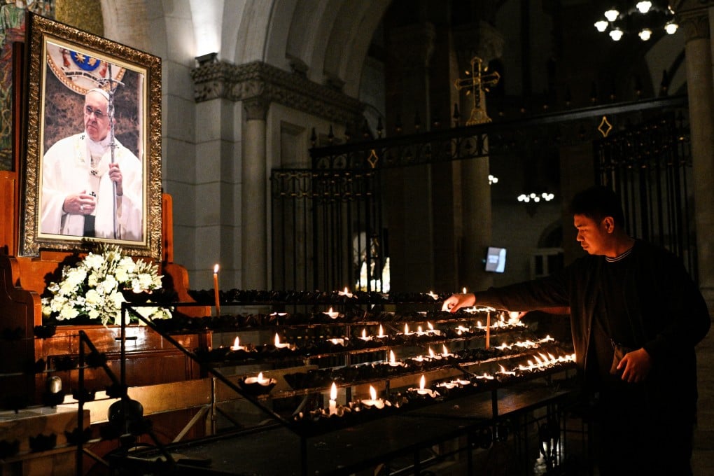 A Filipino offers a candle in front of a picture of Pope Francis, following the Vatican’s announcement of the pontiff’s death, at the Manila Cathedral in Manila, the Philippines, on Monday. Photo: Reuters