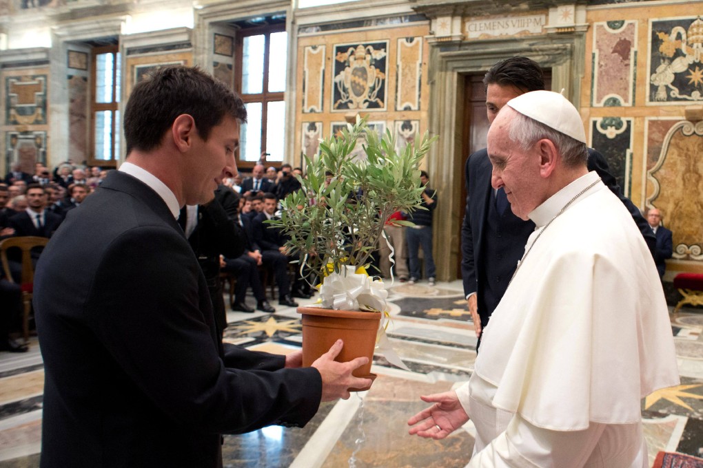 Pope Francis receives an olive tree from Argentine forward Lionel Messi at the end of a private audience together at the Vatican in Rome, Italy on August 13, 2013. Photo: Osservatore Romano / AFP