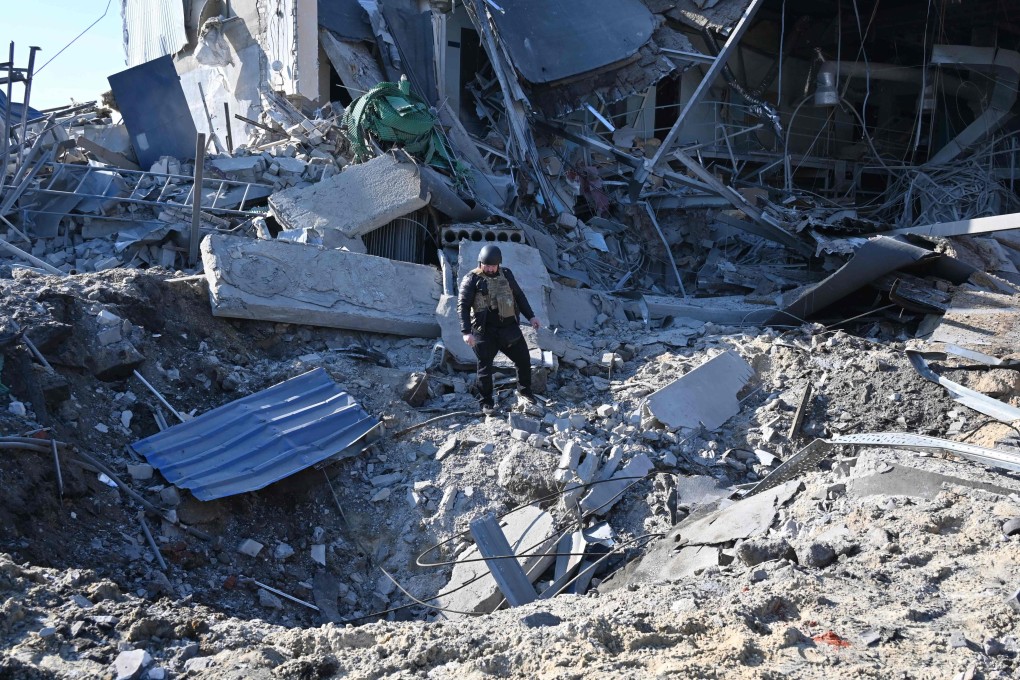 A law enforcement officer inspects a crater next to a destroyed building following a missile attack in Kharkiv, Ukraine, on April 18. Photo: AFP