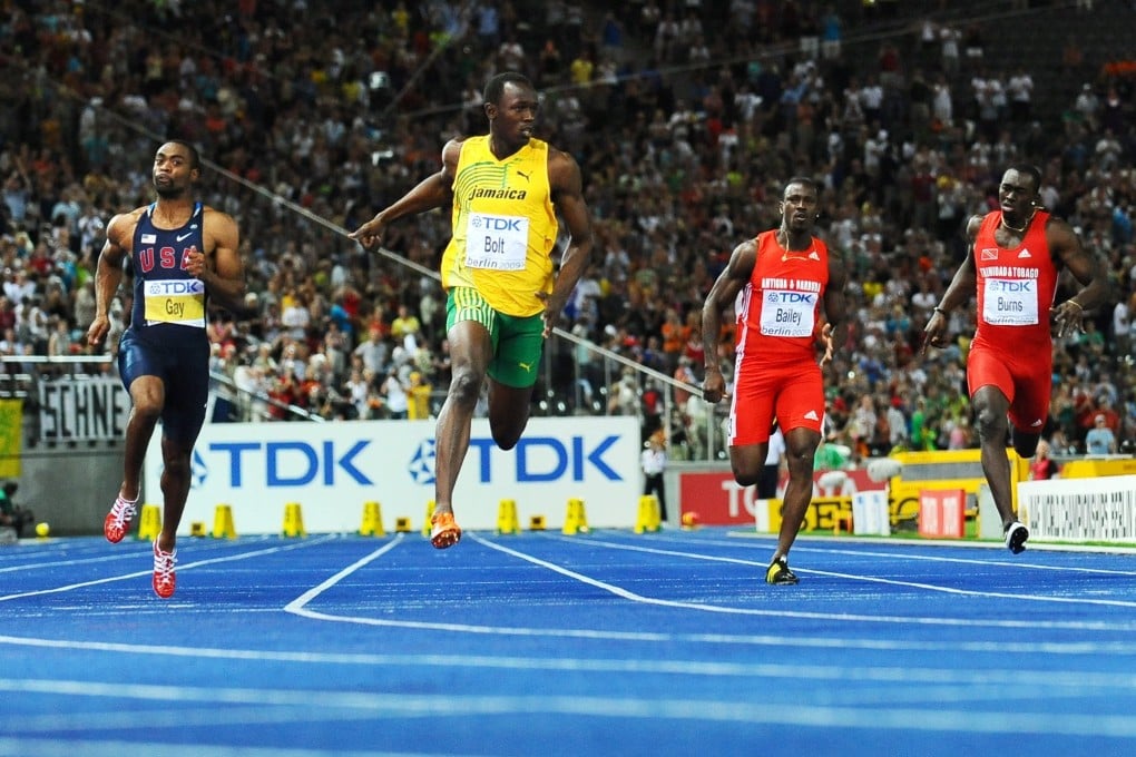 Jamaica’s Usain Bolt (centre, in yellow) crosses the finish line in a new world record time to win global 100m gold in 2009. Photo: AFP