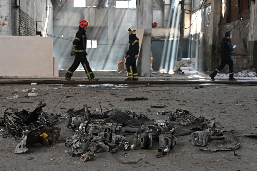 Ukrainian firefighters walk past remains of drones following a Russian strike in Kharkiv on Tuesday. Photo: AFP