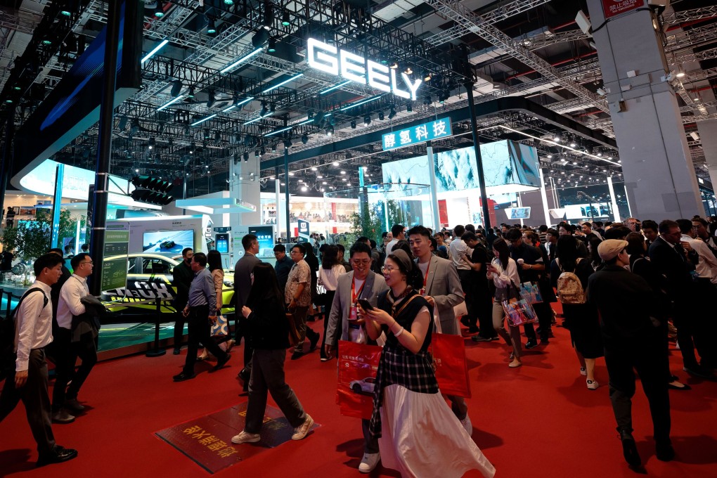 Visitors walk in front of the Geely booth during the Shanghai auto show on April 23, 2025. Photo: EPA-EFE