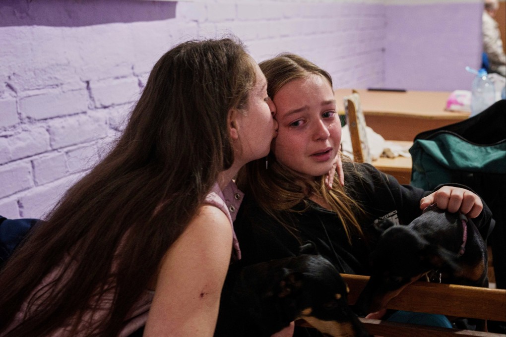 A mother comforts her daughter in a school basement they are using as a shelter after a Russian air strike in Kyiv, Ukraine, on Thursday. Photo: AP
