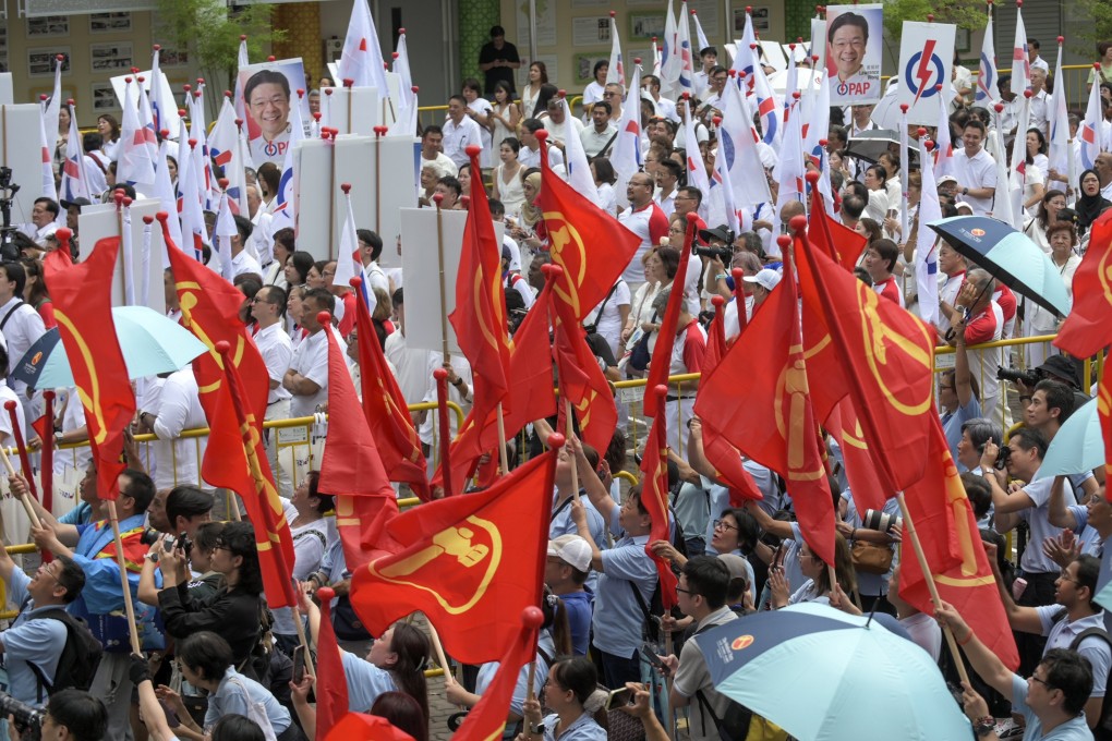 Supporters of the opposition Workers Party in red and the ruling People’s Action Party in white wave flags in support of their political party at a nomination centre in Singapore on Wednesday. Photo: EPA-EFE