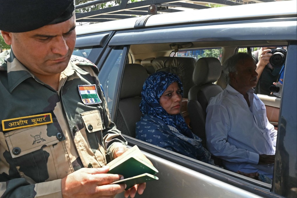 An Indian Border Security Force personnel checks passports of Pakistan citizens returning to their country through the India-Pakistan Wagah border post on Thursday. Photo: AFP