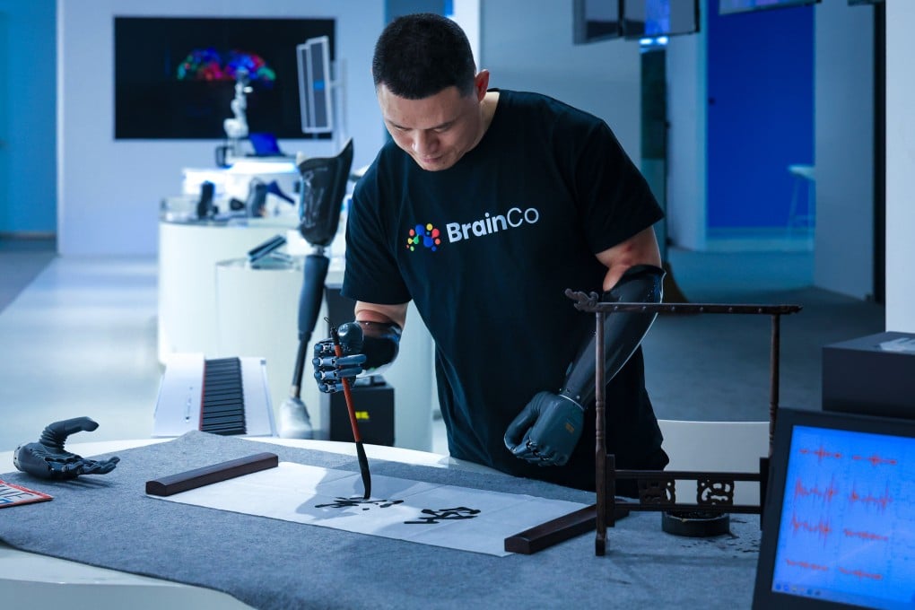 BrainCo product experience officer Ni Mincheng uses brain waves to control robotic arms. Photo: Dickson Lee