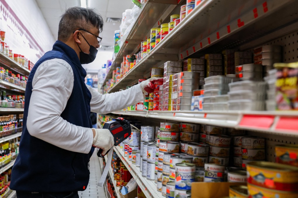 A grocery shop employee adds price tags and stocks shelves in Chinatown in New York on April 16. Photo: Reuters