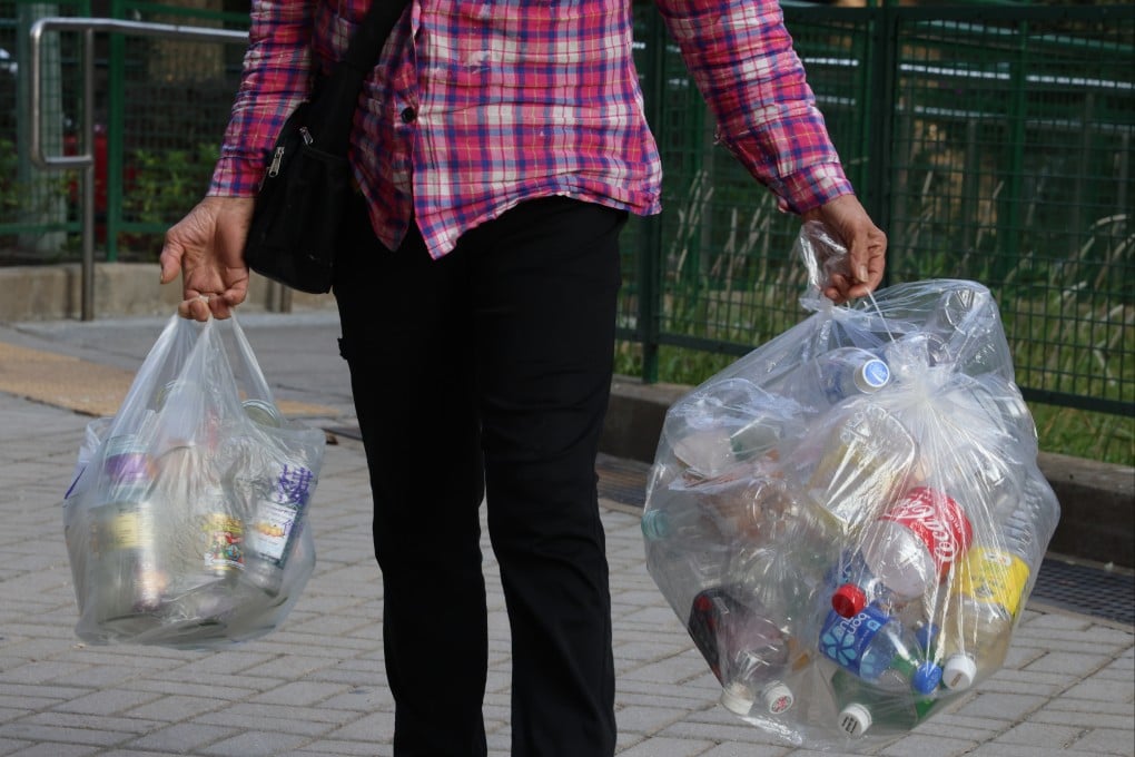 A resident takes plastic bottles to the Green@Community recycling collection point at Shek Lei Estate in Kwai Ching on January 9. Photo: Jelly Tse