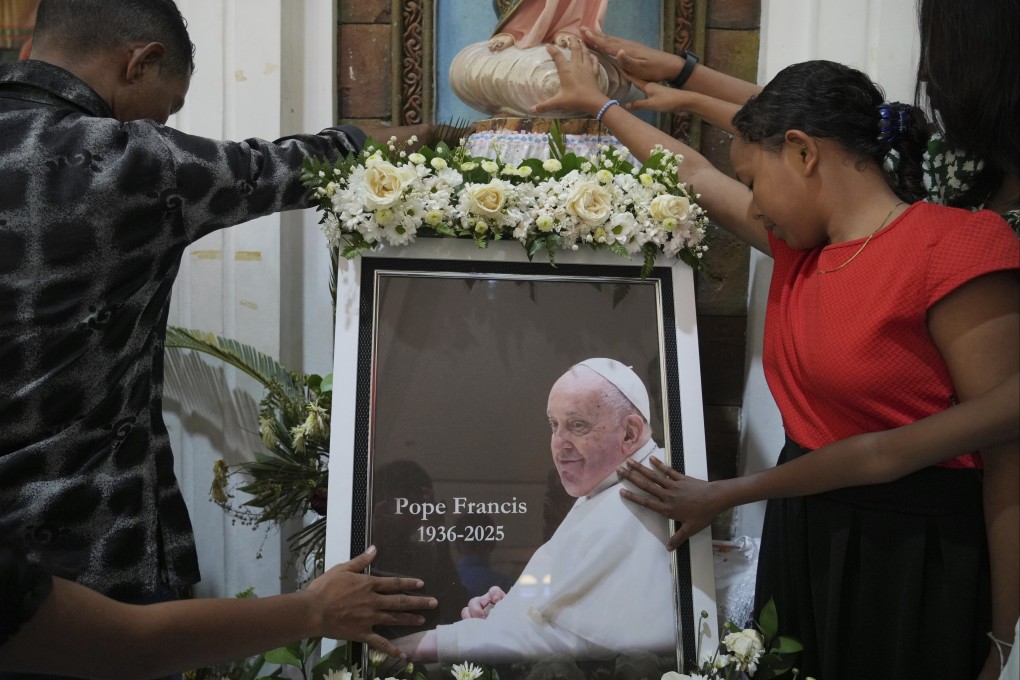 Parishioners pray for the late Pope Francis during a mass in Dili, East Timor, on Sunday. Photo: AP