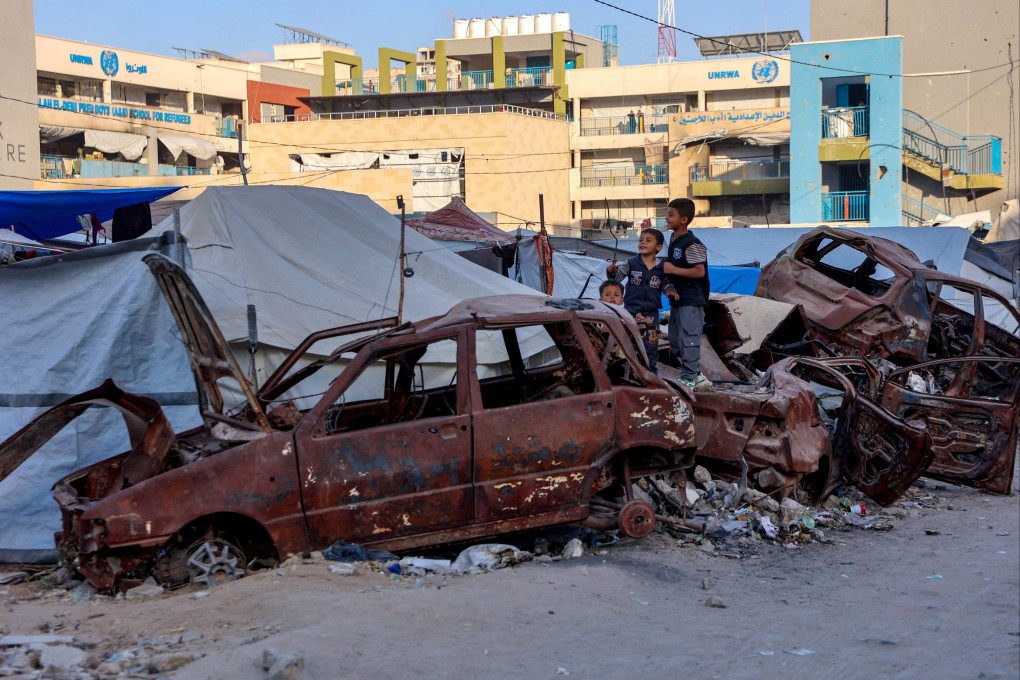 Palestinian children play on destroyed cars outside a UNRWA school housing refugees in Gaza City on Saturday. Photo: AFP