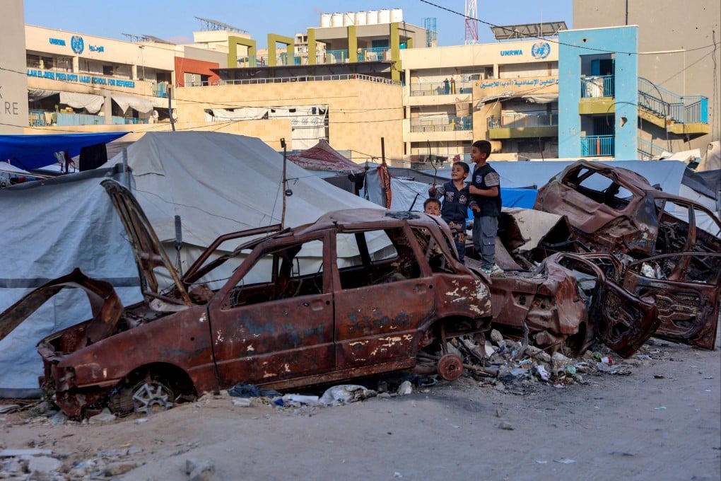 Palestinian children play on destroyed cars outside a UNRWA school housing refugees in Gaza City on Saturday. Photo: AFP