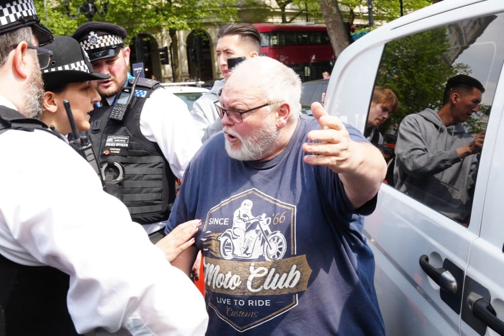 A driver speaks to police officers after protesters from Just Stop Oil blocked the road in London on Saturday. Photo: PA Wire via dpa