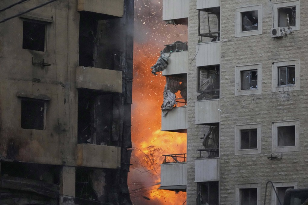 Flames rise between two buildings after an Israeli air strike on Dahiyeh, in the southern suburbs of Beirut. Photo: AP