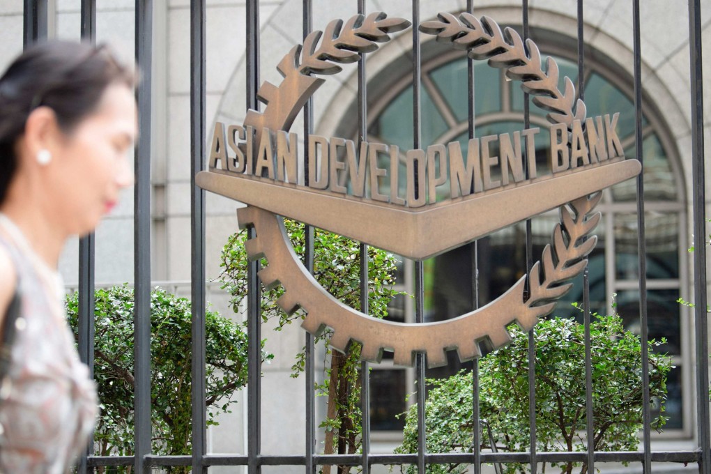 A woman walks past the Asian Development Bank’s headquarters in Manila. Photo: AFP