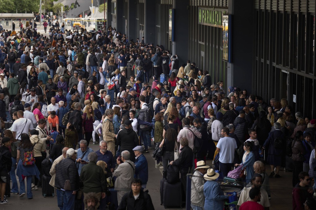 People wait outside a closed train station, during a major power outage in Barcelona, Spain. Photo: AP